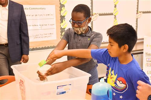 students demonstrating an experiment for visitors